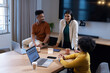 © Wavebreak Media - Diverse coworkers meeting at office wooden table in business attire, using laptops and coffee