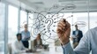 © Brokkk - Business professional drawing a complex problem solving diagram on a glass wall in the office.