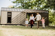© BGStock72 - Family enjoying a sunny day walking in front of their modern cabin home