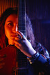 © Jack Tamrong - Cinematic and cool portrait of female guitarist in stylish black rock wear covering half face with  favorite red guitar