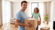 © NikProArt - Cheerful young couple carrying cardboard boxes while moving into a new bright apartment