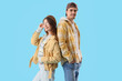© Pixel-Shot - Youth culture and friendship, diverse young couple standing back to back with casual style on a blue background
