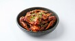 © Pranti - A detailed view of a dark ceramic bowl filled with spicy marinated raw crab topped with sesame seeds and chopped green onions