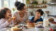© Tikka MS - Mother and two children laughing while eating pancakes for breakfast in a bright kitchen