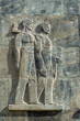 © photoopus - Stone relief sculpture depicting two male laborers, one carrying a hammer and the other an axe, symbolizing work, industry, and building a strong future