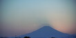© BRUCE - 明け方の薄明の時間帯に浮かび上がる富士山のシルエット。山頂から伸びる影が美しいグラデーションの空に映える神秘的な日本の風景。