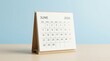 © MheeP - June 2026 calendar on a wooden desk, representing schedule and event planning.