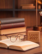 © SH Art Solutions - Bücherstapel mit Brille und Holzblock Learn 2027 im warmen Schreibtischlicht