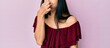 © The DiTech - Woman touching her nose bridge against pink background feeling discomfort