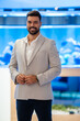 © Zoran Jesic - Confident businessman in stylish light blazer smiling indoors