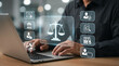 © Sonia - Professional man using a laptop with digital legal symbols and scales of justice