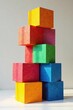 © vattana - A vibrant stack of colorful cubic blocks, exhibiting a playful arrangement of textured surfaces and diverse hues, showcasing a dynamic interplay of light and shadow.