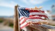 © Pinklife - A close-up of a weathered American flag flutters in the gentle breeze, symbolizing patriotism and the spirit of freedom against a beautiful landscape.