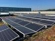 © Nataschen - Solar panels installed on a rooftop with green vegetation surrounding them, for solar panel maintenance and cleaning content, renewable energy infrastructure upkeep