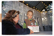 © Ivan Haidutski/Stocksy - Child blowing out candles on granny’s 53rd birthday cake