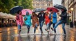 © BazCam - Happy diverse group of friends wearing colorful raincoats and holding umbrellas while splashing and having fun on a rainy city street