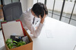 © Charlie's - Asian Businessman Touching Forehead with Headache at Office Desk Experiencing Burnout Stress and Emotional Pain from Boring Job.