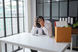 © Charlie's - Asian Businessman Touching Forehead with Headache at Office Desk Experiencing Burnout Stress and Emotional Pain from Boring Job.