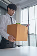 © Charlie's - Businessman Carrying Cardboard Box packing Stuff Resign Depress or carrying business cardboard box Change of job or fired from company resign.
