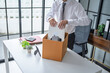 © Charlie's - Businessman Carrying Cardboard Box packing Stuff Resign Depress or carrying business cardboard box Change of job or fired from company resign.