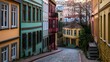 © Wuttichai - A narrow cobblestone street lined with colorful buildings  featuring   balconies  and staircases under soft evening light