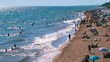 © Generative AI - Crowded beach scene with people swimming and sunbathing