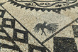 © hectorchristiaen - A finely crafted Halki pebble mosaic with bird motif and geometric pattern, built from smooth stone in light and dark contrast — a traditional island artwork full of rhythm and precision.