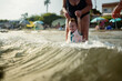 © Raul Navarro/Stocksy - Grandmother helping child playing in ocean waves
