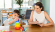 © JackF - Professional child psychologist observing little boy assembling toy pyramid on table at development center