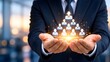 © Samsir - Businessman in suit holding a glowing digital hologram of a corporate team hierarchy pyramid illustrating human resources and leadership.