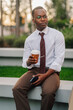 © Ljustina - African american businessman having coffee break outdoors
