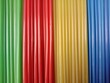 © Bahreni - Bright multicolored plastic straws close up background, rows of vibrant green, red, yellow, and blue tubes.