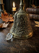 © MNFTs - Vintage brass bell with intricate designs, featuring spider and cobwebs, evokes mysterious