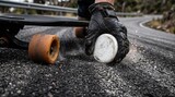 Dynamic close-up of a longboarder dragging a gloved hand with slide pucks on asphalt creating bright sparks during downhill skating.