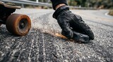 Dynamic close-up of a longboarder dragging a gloved hand with slide pucks on asphalt creating bright sparks during downhill skating.