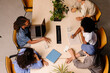 © Adrian Rodd/Stocksy - Professionals working remotely from a shared coworking desk.