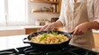 © Rendara Studio - Skilled cook flipping pasta shells with fresh basil in smoking skillet