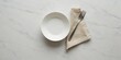 © Avinash - Empty white ceramic bowl with silver fork and linen napkin on elegant marble table background with copy space