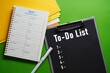 © AhmadYani - TO-DO LIST. Work-related concept. Self-development. Managing tasks to be completed. Prioritizing to boost productivity. Background featuring a note file and a 2027 monthly schedule