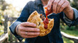 © tangmo.pa - Hands squeezing tomato sauce onto a hot savory meat pie outdoors on sunny day