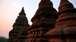 © Thares2020 - Ancient stone stupas stand in serene alignment under soft twilight sky  showcasing layered brickwork and timeless architectural design