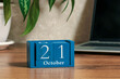 © Dmitrii Labrador - October 21.  calendar made of cubes on a computer desk with a houseplant. The concept of a deadline for completing a task, an important date, or an event.