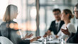 © CreativeArt - Business professionals having discussion in blurred modern corporate meeting room