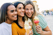 © Xavier Lorenzo - Female friends enjoying ice cream together outdoors. Young women sharing sweet moments during summer vacation. Lifestyle and leisure concept.