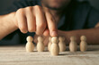 © Artvibe - Businessman with wooden figures of people. The concept of business and management.