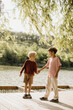 © BGStock72 - Two young boys enjoying a sunny day by the lakeside while holding hands