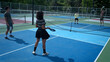 © Wosunan - Male and female pickleball players enjoy playing the game on an outdoor doubles court, demonstrating concentration,