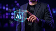 © Nasima88 - Businessman touching a glowing digital cube with AI letters and tech data interface