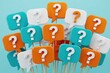© miss irine - Colorful question mark speech bubbles on wooden sticks. Group of turquoise orange, white chat icons for communication concept. Many symbols for doubt curiosity, problem solving. People ask questions