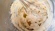 © Solizonka - Fresh lemon-colored custard cream whipped with a whisk in a stainless steel bowl, showing its light and airy texture. The close-up baking scene represents homemade desserts, cake preparation